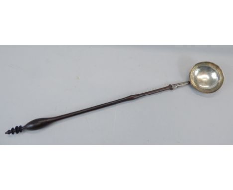 A 19thC continental white metal ladle, with turned wooden handle, engraved initials to the bowl, 40cm long. 