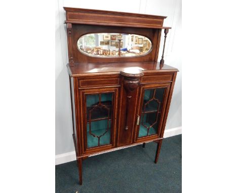 An Edwardian mahogany and chequer banded display cabinet, the raised back with an oval bevelled mirror plate, on turned suppo