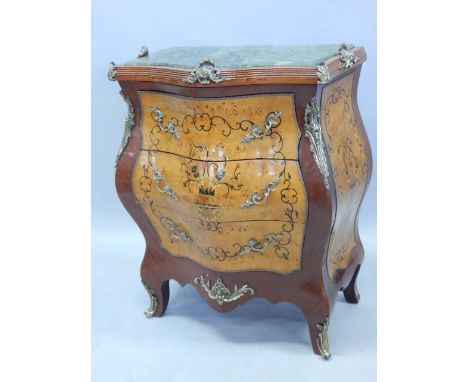 A Continental bombe shaped mahogany commode, with gilt metal mounts, the top with a green marble insert, above three bird's e