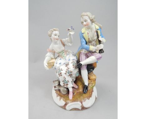 A late 19thC Sitzendorf porcelain figure group, of a gentleman playing a musical instrument, beside a lady holding a bird, in