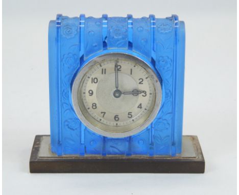 An Art Deco style blue glass mantel timepiece, decorated in relief with bands of flowers, with silvered dial, on rectangular 