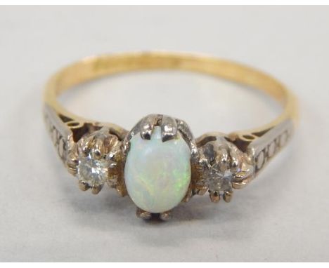 An 18ct gold opal and diamond dress ring, with central opal, flanked by two tiny diamonds, 2.5g all in. 