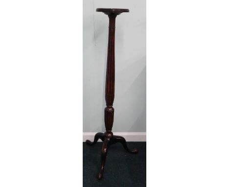A mahogany torchere, the circular galleried top, readed and leaf carved column on tripod base, 146cm high.