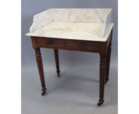 A William IV mahogany wash stand, with a white marble top, above two frieze drawers, on turned tapering legs with ceramic cas