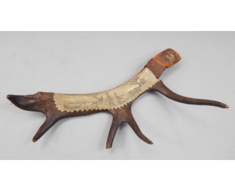An Inuit antler scabbard, with scrimshaw decoration of a reindeer pulling a sled, etc, with a leather collar, recess possibly