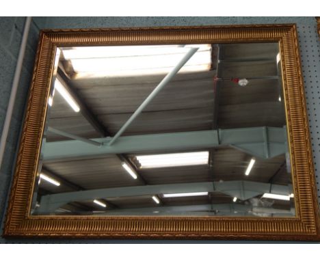 A modern rectangular wall mirror, in a gilt frame and bevel plate