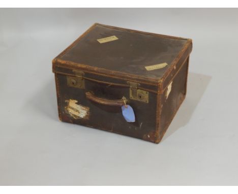 A small canvas and leather bound cabin trunk, bearing various luggage labels, 46cm wide.
