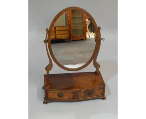 A reproduction figured mahogany dressing table mirror, the bow fronted base, with two drawers, on bracket feet, 45cm wide. 