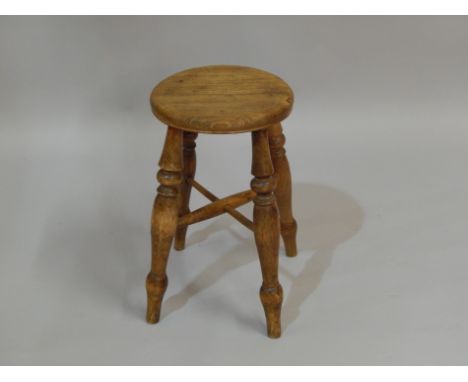 A 19thC country made ash stool, with a circular seat on turned legs.