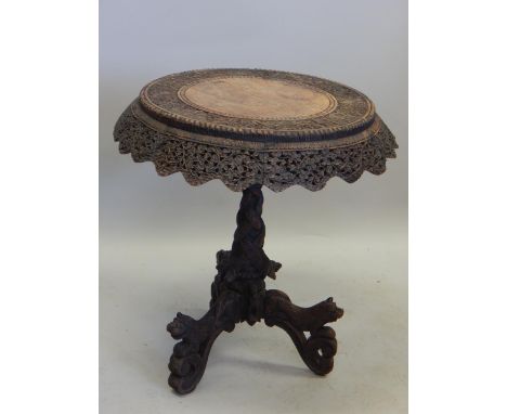 A 19thC Burmese occasional table, the circular top with a pierced border on a turned and serpent carved column with tripod ba