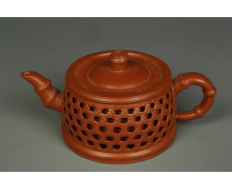 A SMALL CHINESE YIXING RETICULATED TEAPOT of circular form with bamboo spout and handle, 20th century, 5.25" long