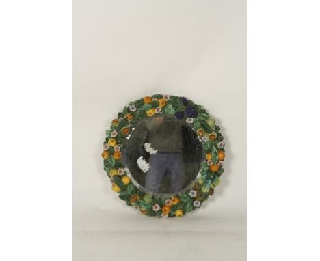 A LATE 19TH CENTURY/EARLY 20TH CENTURY ITALIAN MAJOLICA POTTERY WALL MIRROR, in the style of Della Robbia, of circular form, 