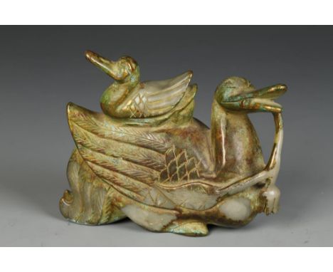 A CHINESE GILT-DECORATED JADE CARVING OF DUCKS, the larger bird holding a flower spray in its mouth and with the young bird s