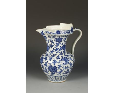 A CHINESE BLUE AND WHITE "MONKS CAP" EWER evenly decorated with flowerheads and leafy tendrils above a lappet band, the scrol