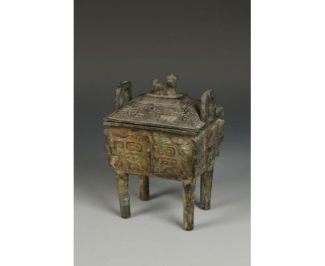 A CHINESE BRONZE ARCHAISTIC DING CENSER with a lion finial, loop handles and scroll decoration, probably Qing, 9" high