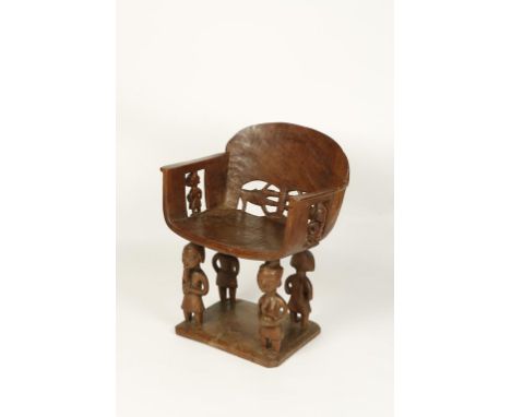 A WEST AFRICAN TRIBAL HARDWOOD CHAIR, the arched back decorated with two stylised animals, the arm supports in the form of fi