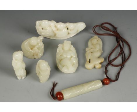 SEVEN CHINESE CELADON JADE PENDANTS, the largest example with a procession of three figures, 3.25" long; three further exampl