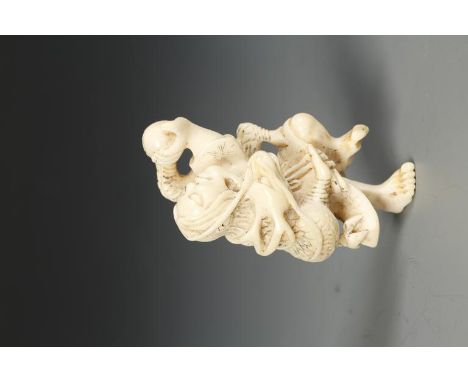 A JAPANESE IVORY RAKAN AND DRAGON NETSUKE, the figure holding a ball aloft with the dragon coiled around its' body, late Edo/