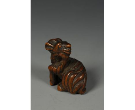 A JAPANESE WOOD GOAT NETSUKE, the creature with its' head turned backwards and inlaid eyes, late Edo/Meiji, 1.5" high