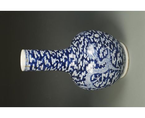 A CHINESE BLUE AND WHITE BOTTLE VASE decorated with two opposing dragons on a cloud scroll ground, the base with a four chara