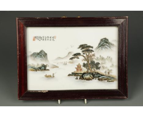 A CHINESE FAMILLE VERTE PANEL showing figures and a pagoda in a lake and mountain landscape, with calligraphy and seal marks,