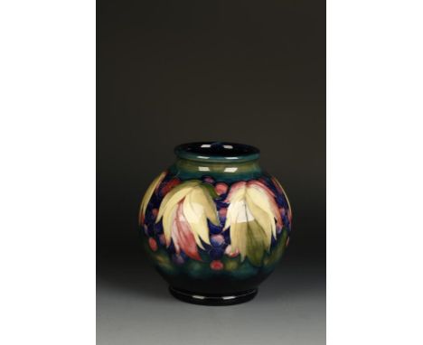 A WILLIAM MOORCROFT VASE of globe form, decorated with a leaf and berry pattern against a graduated blue/green ground, the un