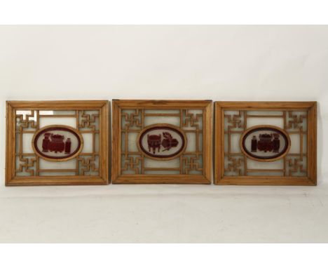 THREE CHINESE WOOD AND GLASS ARCHITECTURAL PANELS, each showing a central oval glass panel with precious objects surrounded b