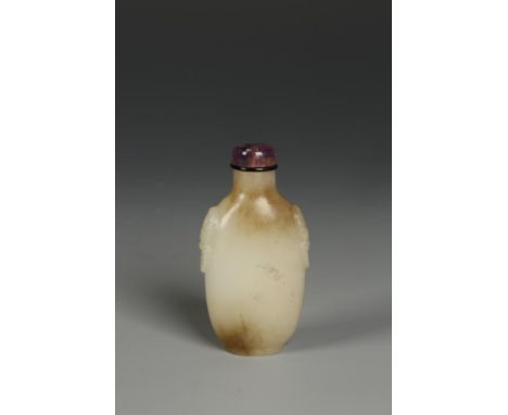 A CHINESE CELADON JADE SNUFF BOTTLE of slender ovoid form with mask handles, the stone with some darker areas, Qing, 2.75" hi