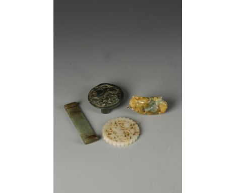 FOUR CHINESE JADE CARVINGS including a miniature scroll-form stand, Ming, 3.5" long; a jadeite pendant, 20th century, 2.252 l