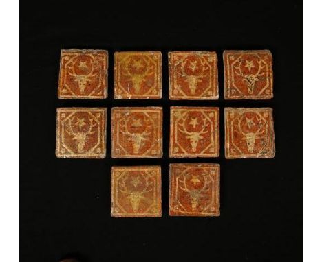 A SET OF TEN ANGLO-FRENCH TERRACOTTA FLOOR TILES, each with yellow stag head and star motif within a hexagonal star border an