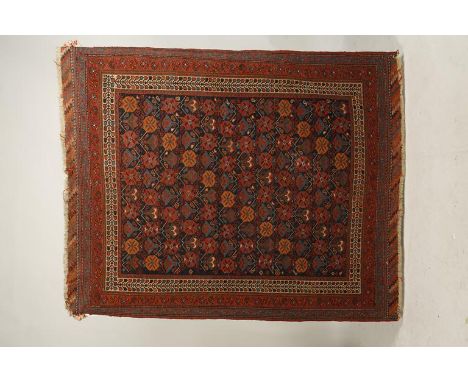 A NORTH-WEST PERSIAN TRIBAL RUG, the central rectangular blue ground panel worked with multi-coloured floral motifs, within i