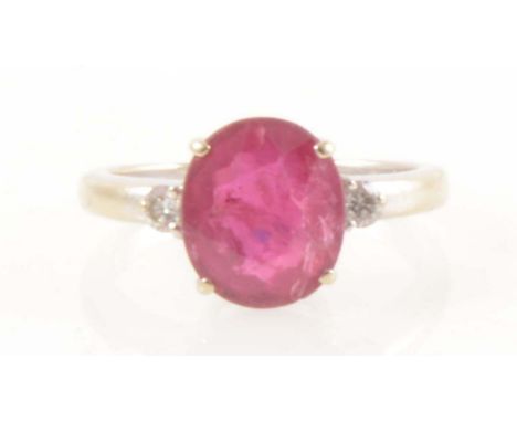 A ruby and diamond three stone ring, an oval mixed cut ruby, 10.56mm x 9.04mm x 4.75mm, four claw set with a brilliant cut di