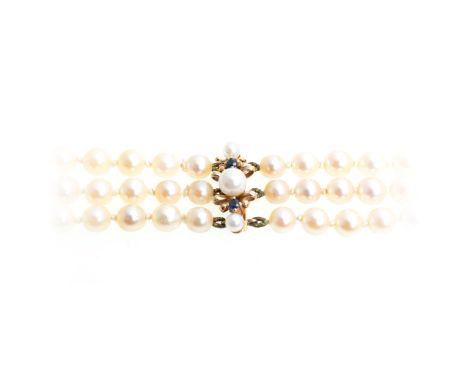 A three row cultured pearl necklace with sapphire and pearl clasp, the three rows of pearls (63), (67), (71), graduating from