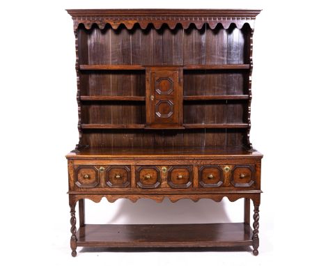 An oak dresser, late 18th Century and later, moulded cornice, three shelf delft rack incorporating central cupboard with a re