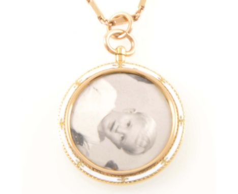 An enamel photo frame pendant and chain, the 35mm diameter double sided frame decorated with white enamel on a 9 carat yellow