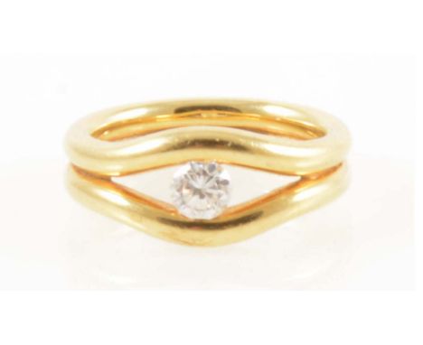 An 18 carat yellow gold ring set with a diamond, the brilliant cut stone set between a pair of 2.5mm gold bands parting at th