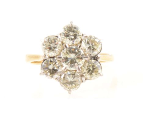 A floral diamond cluster ring, seven brilliant cut diamonds claw set in an 18 carat yellow and white gold circular cluster ri