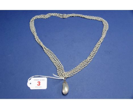A large Baroque pearl in a mine cut diamond set mount on an associated four strand freshwater pearl necklace.   Condition Rep