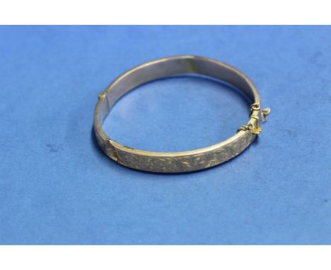 A 9ct gold engraved bangle, 9.2g.
