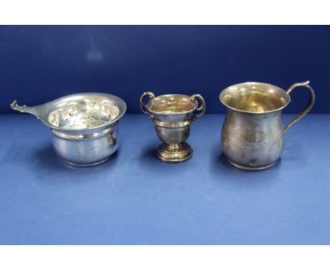 A silver tea strainer on matching stand, by Alexander Clarke Co Ltd, Birmingham 1938 together with a silver christening mug a