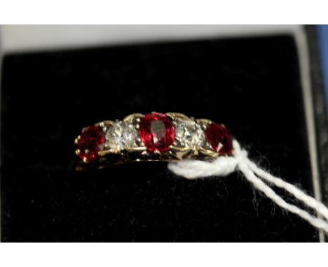 An 18ct gold ring set three rubies and two diamonds.   Condition Report:  Considerable wear and tear.  One diamond chipped, o