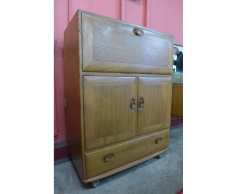 An Ercol Blonde elm and beech Windsor writing cabinet 