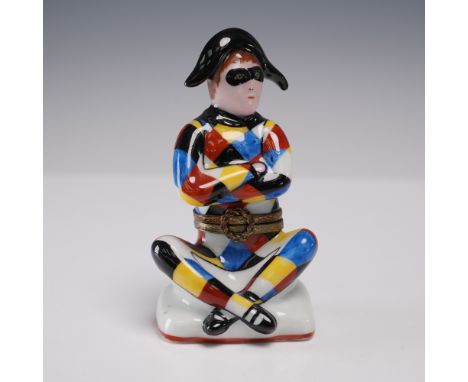 Vibrant hand-painted porcelain trinket box depicting a cross-legged Harlequin in a dazzling patchwork of red, yellow, blue, a