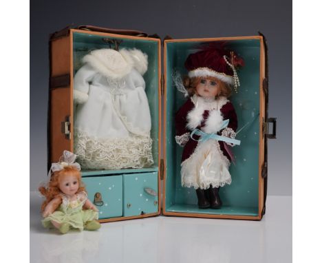 Two collectible porcelain dolls, including Trudy's Holiday, a finely dressed Victorian inspired doll in a red velvet coat wit