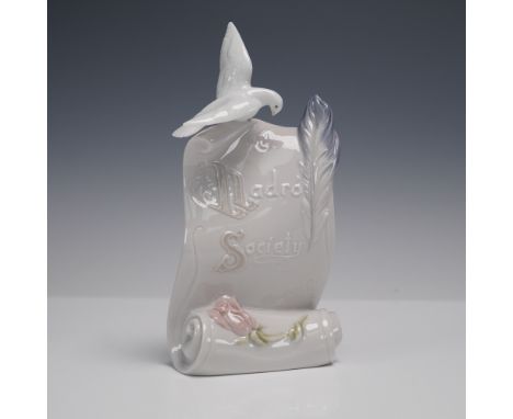 Lladro porcelain figurine featuring an open scroll accented with delicate raised lettering reading Lladro Society. A white do