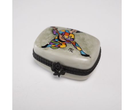 Hand-painted in Limoges, France, this whimsical porcelain box depicts a joyful harlequin musician in a vibrant patchwork cost