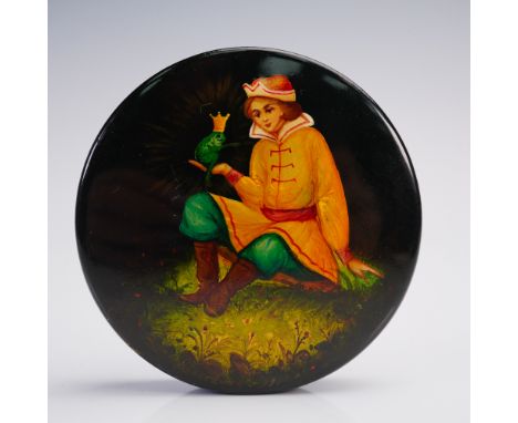 A finely executed Russian lacquer box of circular form, decorated with a vibrant hand-painted scene inspired by the fairy tal