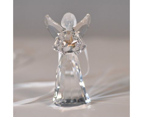Swarovski crystal angel ornament featuring a faceted clear crystal body, frosted face, and outstretched wings, holding a gold