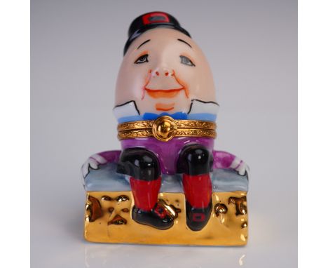 Delightful hand-painted Limoges porcelain box by Sinclair, dated 1999, modeled as Humpty Dumpty seated on a golden brick wall