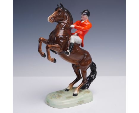 This striking porcelain figurine by Beswick captures a traditional English huntsman in full regalia astride a powerful, reari